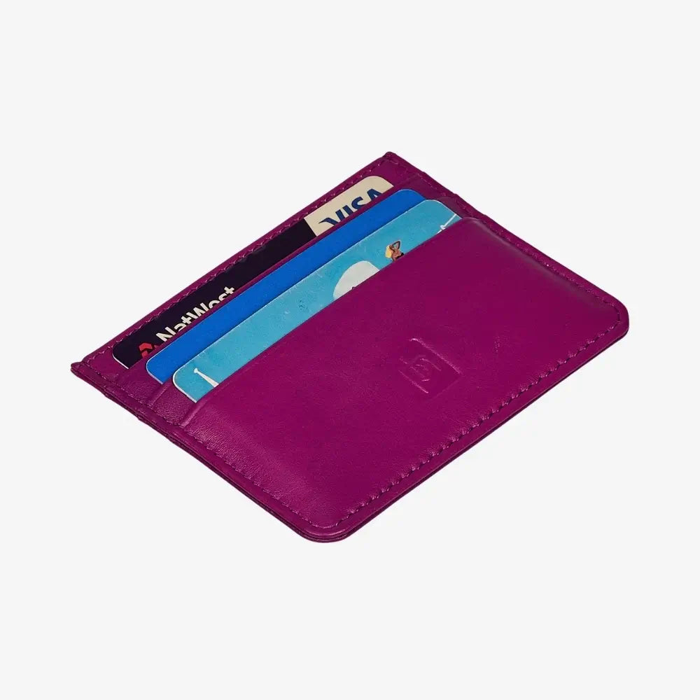 A fuchsia cardholder wallet shown open, displaying its interior card slots with several sample credit cards inserted and a debossed logo on the front cover, set against a plain light gray background.