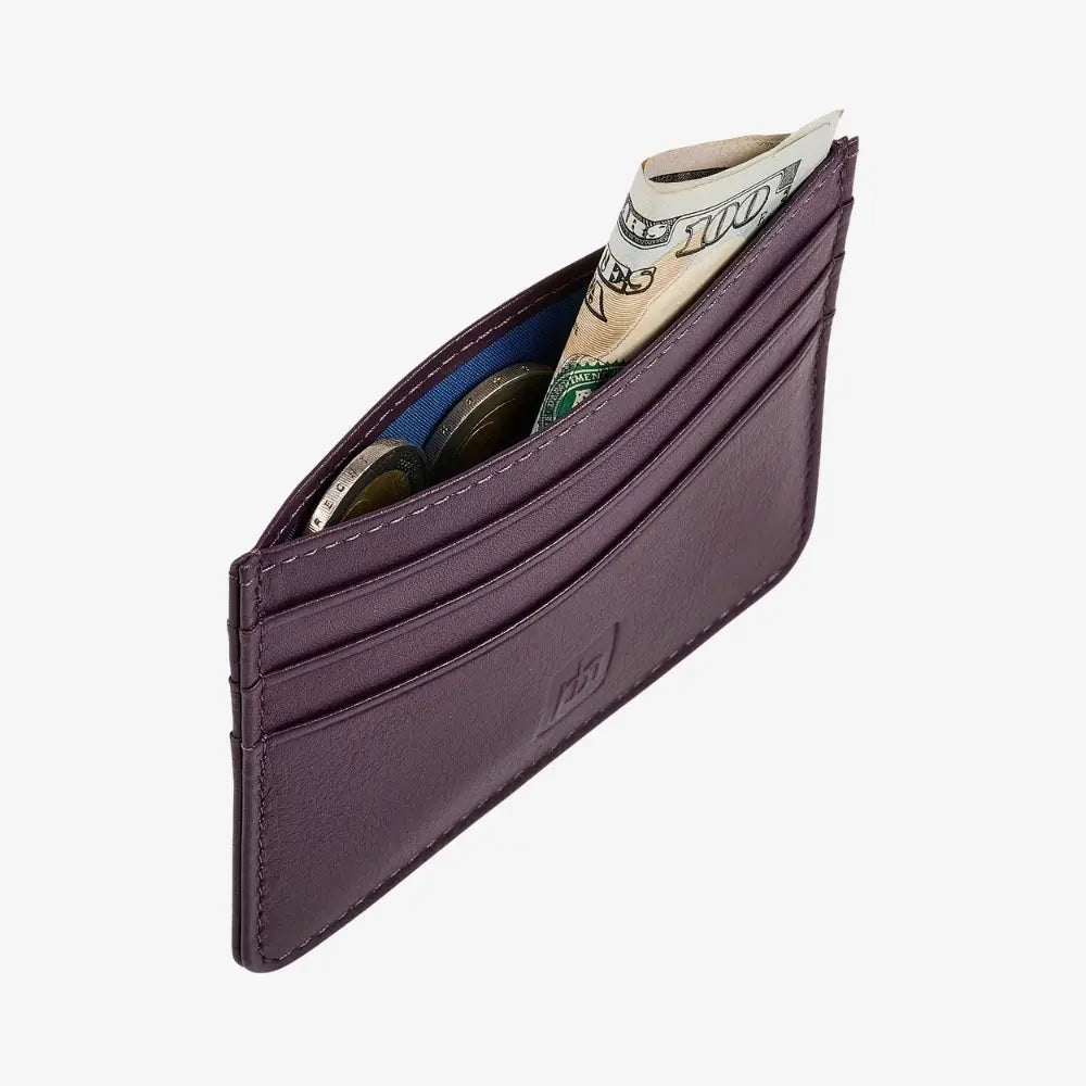 Side angle view of purple leather card holder with coins inside it.