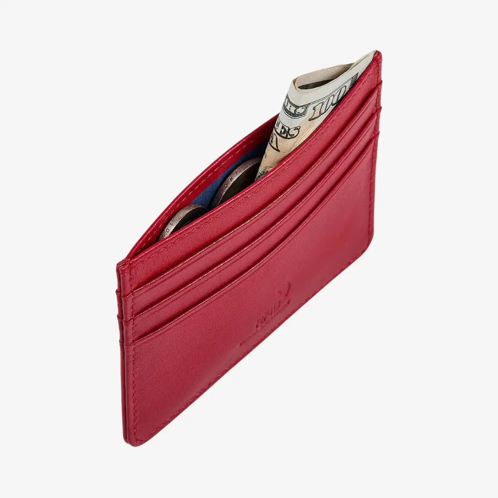 A slim red leather cardholder wallet shown open, containing several cards and a rolled dollar bill, photographed on a clean white background.