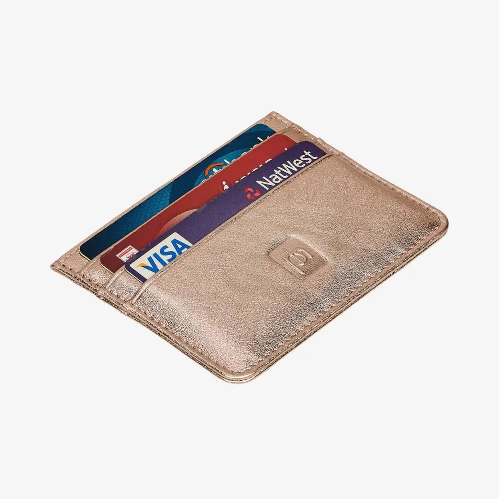 Top view of rose gold leather card holder on agrey background.