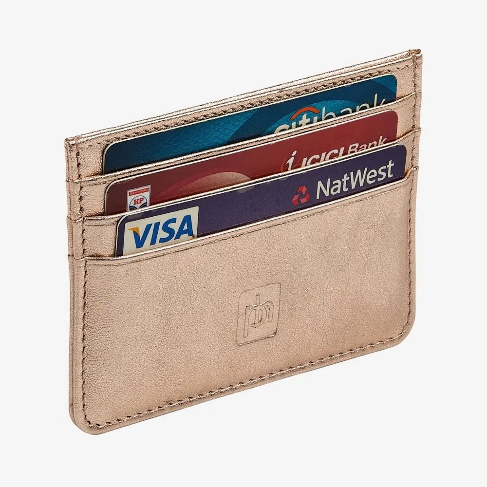 A slim, minimalist cardholder wallet made of rose gold leather, holding four credit cards (including Visa, NatWest, and Citibank). The wallet features a debossed logo on the front and is photographed on a clean, light gray background.