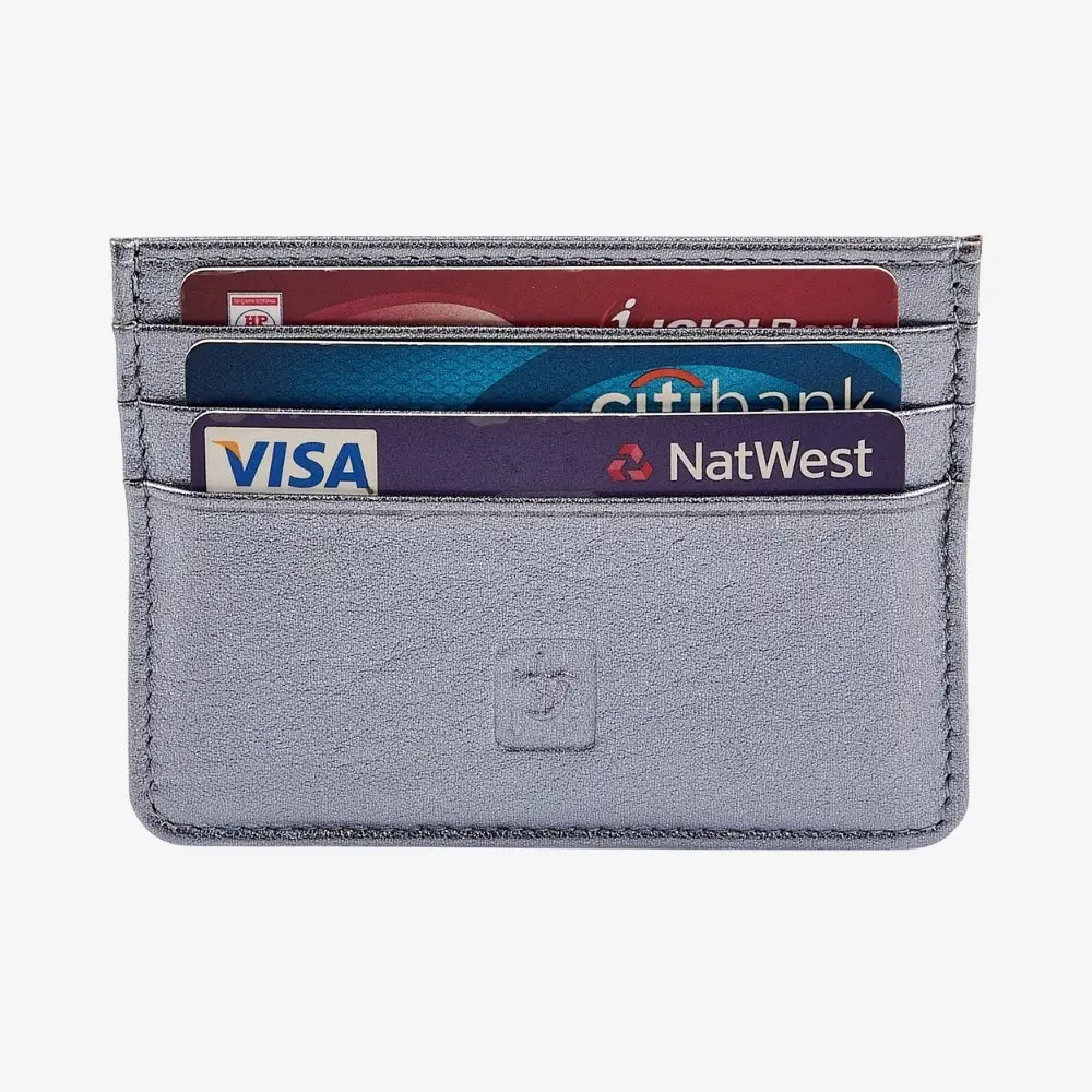 A slim, light sliver leather card holder wallet with four card slots containing sample credit cards, set against a plain light gray background.