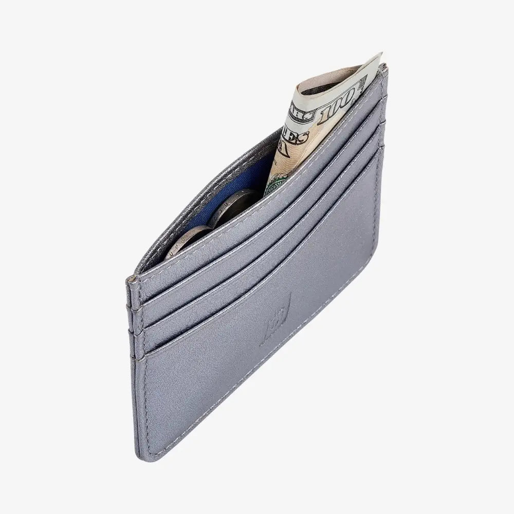 A slim sliver leather card holder wallet with several card slots and a rolled dollar bill partially visible, shown on a light gray background.