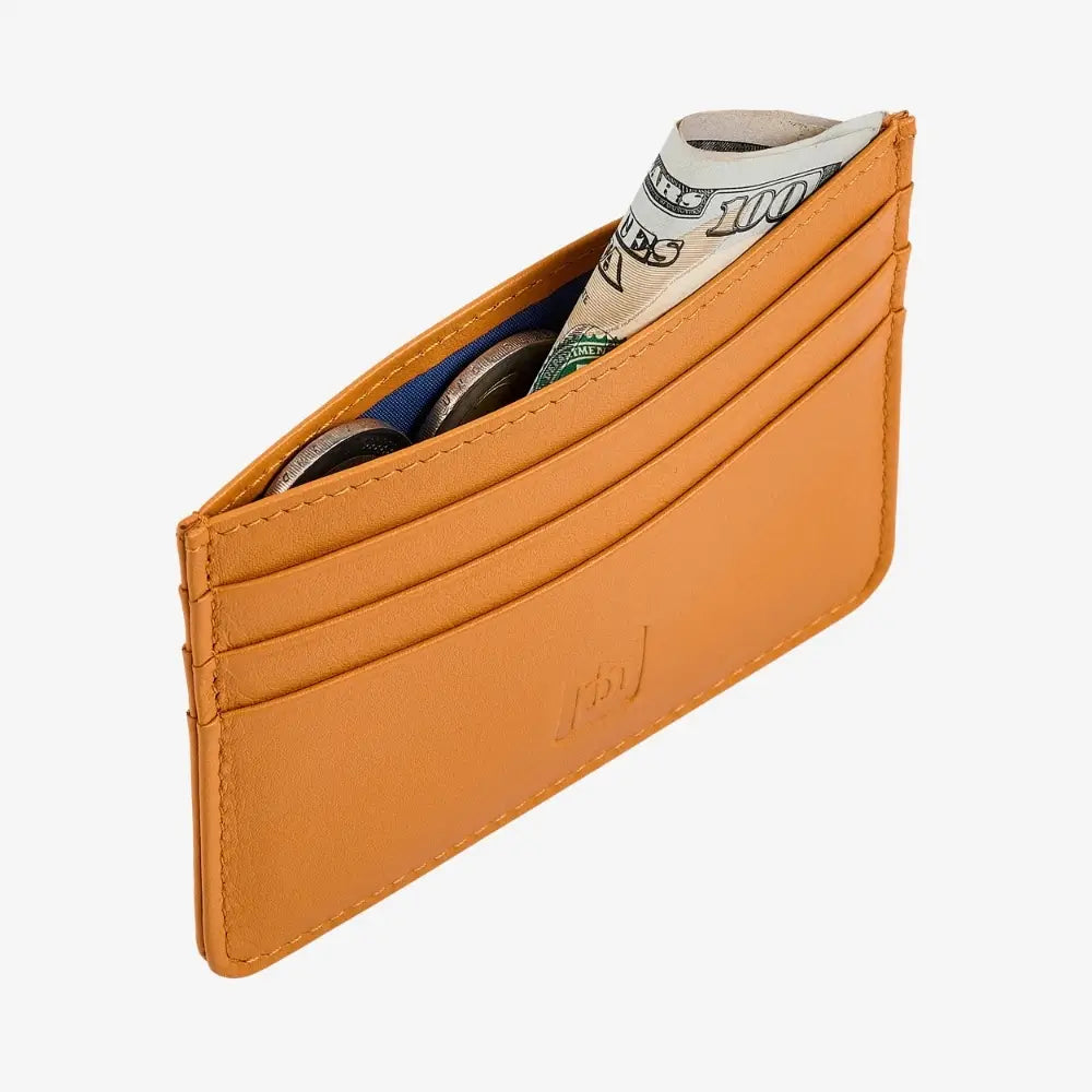 Side angle view of yellow leather card holder on agrey background.