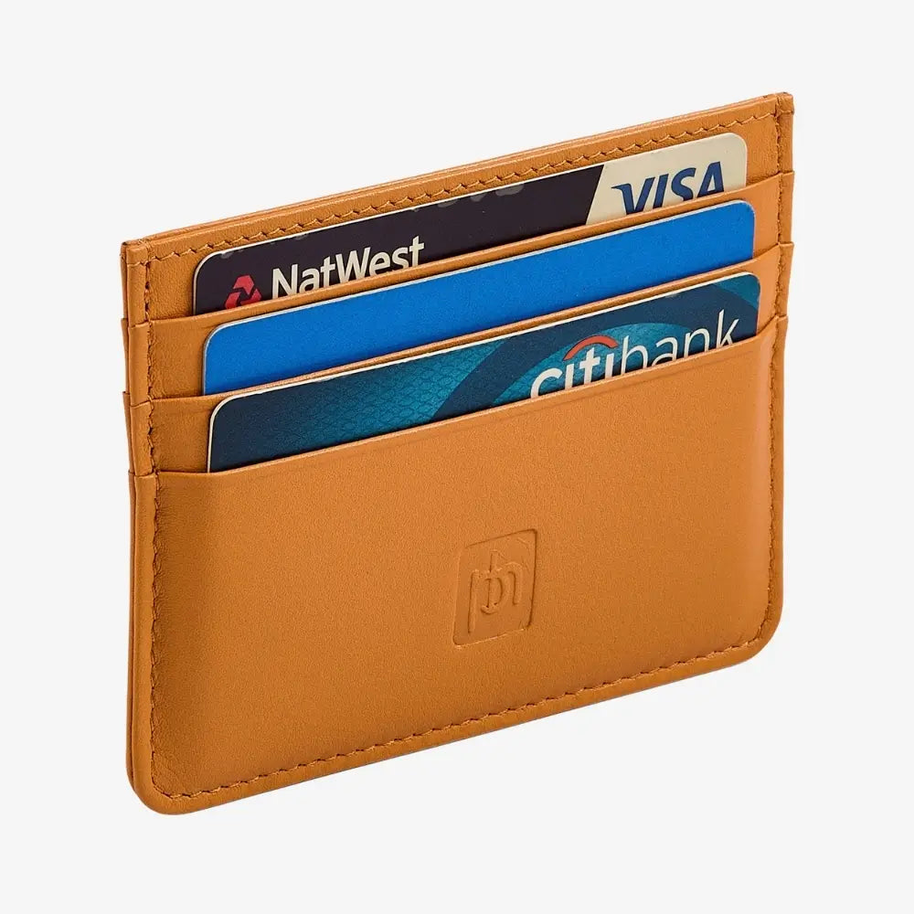 Side angle view of yellow leather card holder on agrey background.