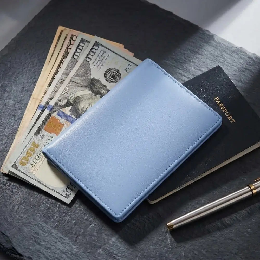 A blue leather passport holder,  shown closed and placed on a dark slate surface with U.S.