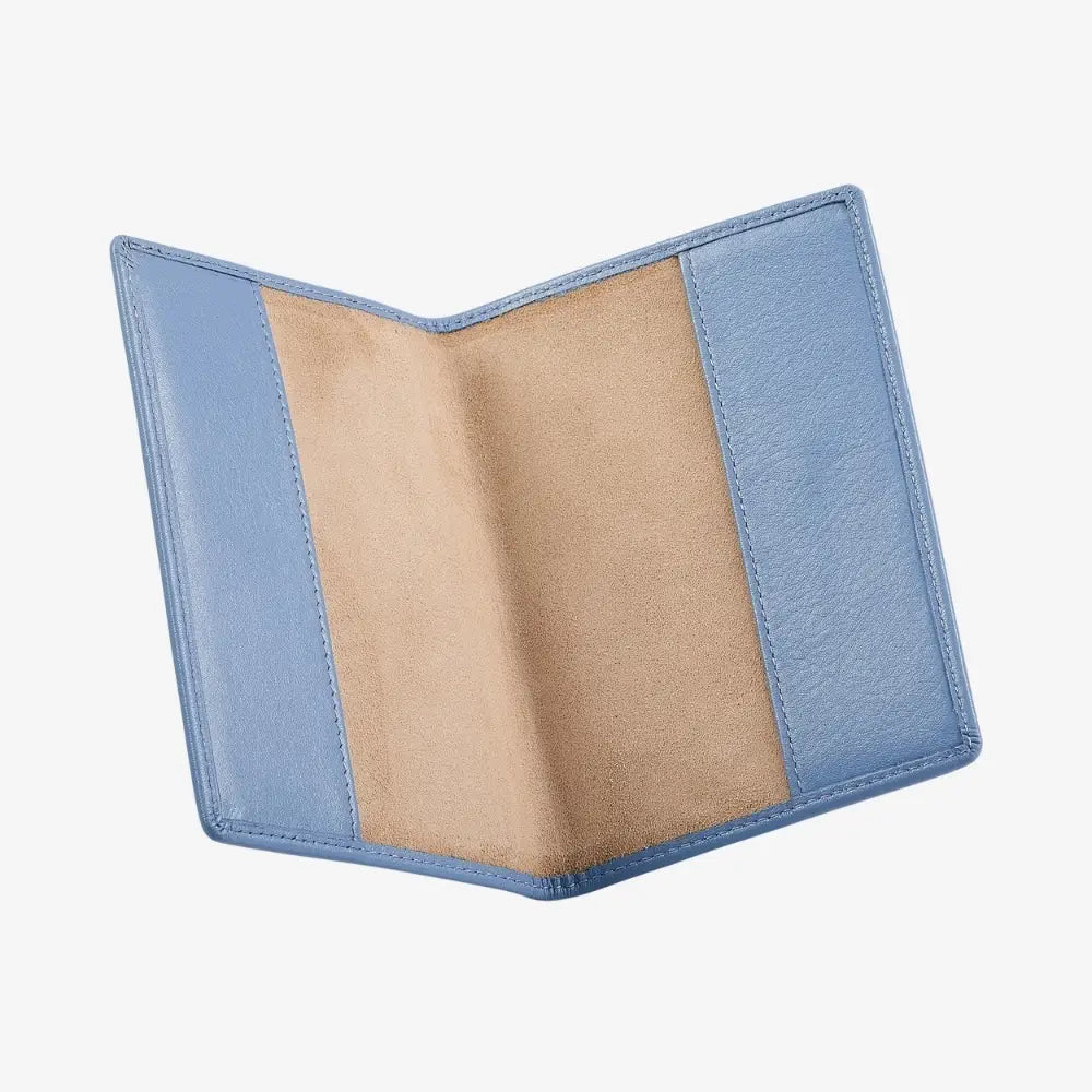 An open bifold passport holder made of blue leather, showing a tan suede-like interior lining, set against a plain light gray background.