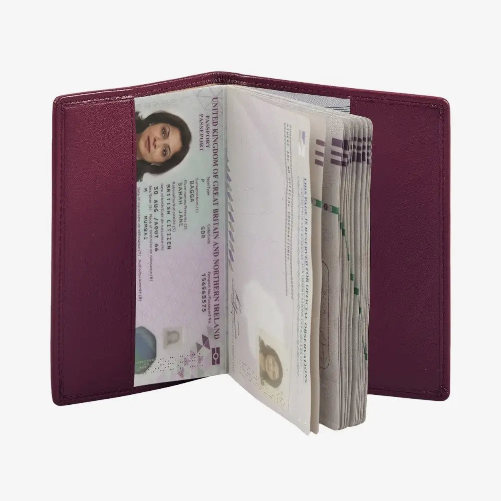 A burgundy leather passport holder shown open, containing several passports and a stack of cash, photographed against a plain white background.