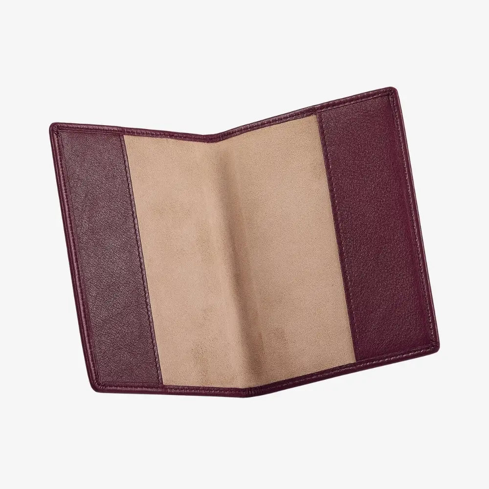 An open leather passport cover with burgundy outer panels and a tan suede-like center panel, shown on a plain light gray background.