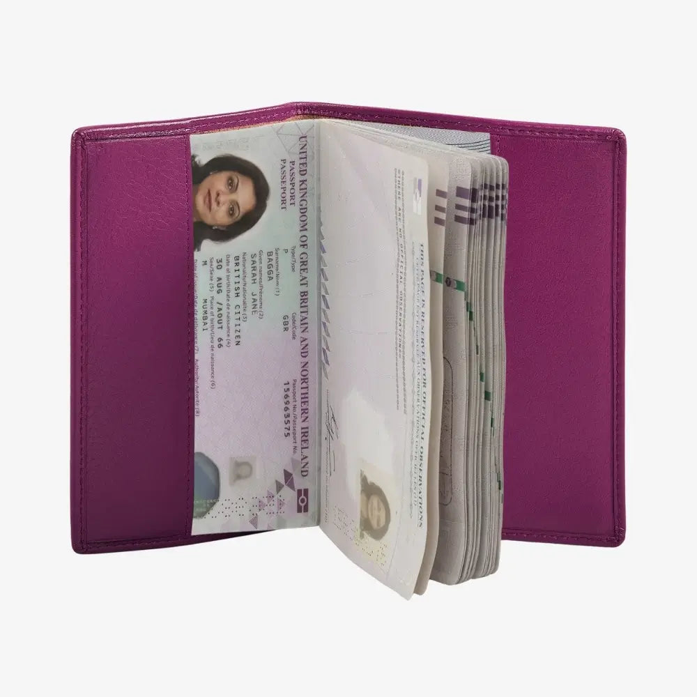 A fuchsia leather passport cover shown open, containing a passport and a stack of cash, photographed against a solid white background.