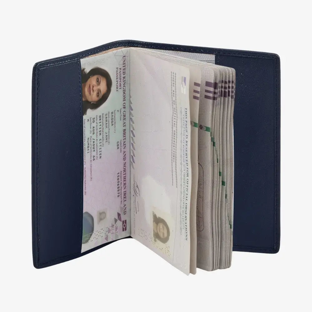 A navy leather passport holder shown open, containing several passports and visas, photographed against a plain white background.
