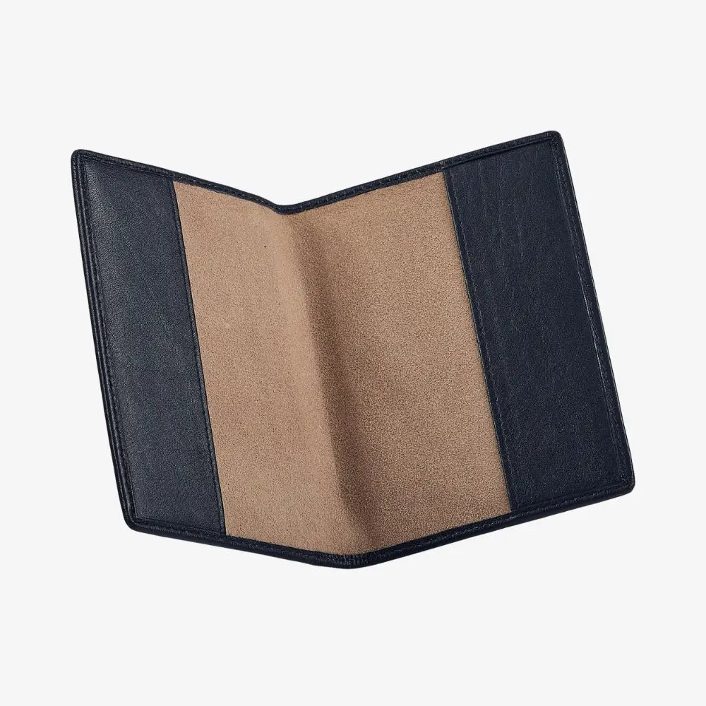 A navy leather passport cover shown open, revealing a tan suede-like interior, set against a plain light gray background.