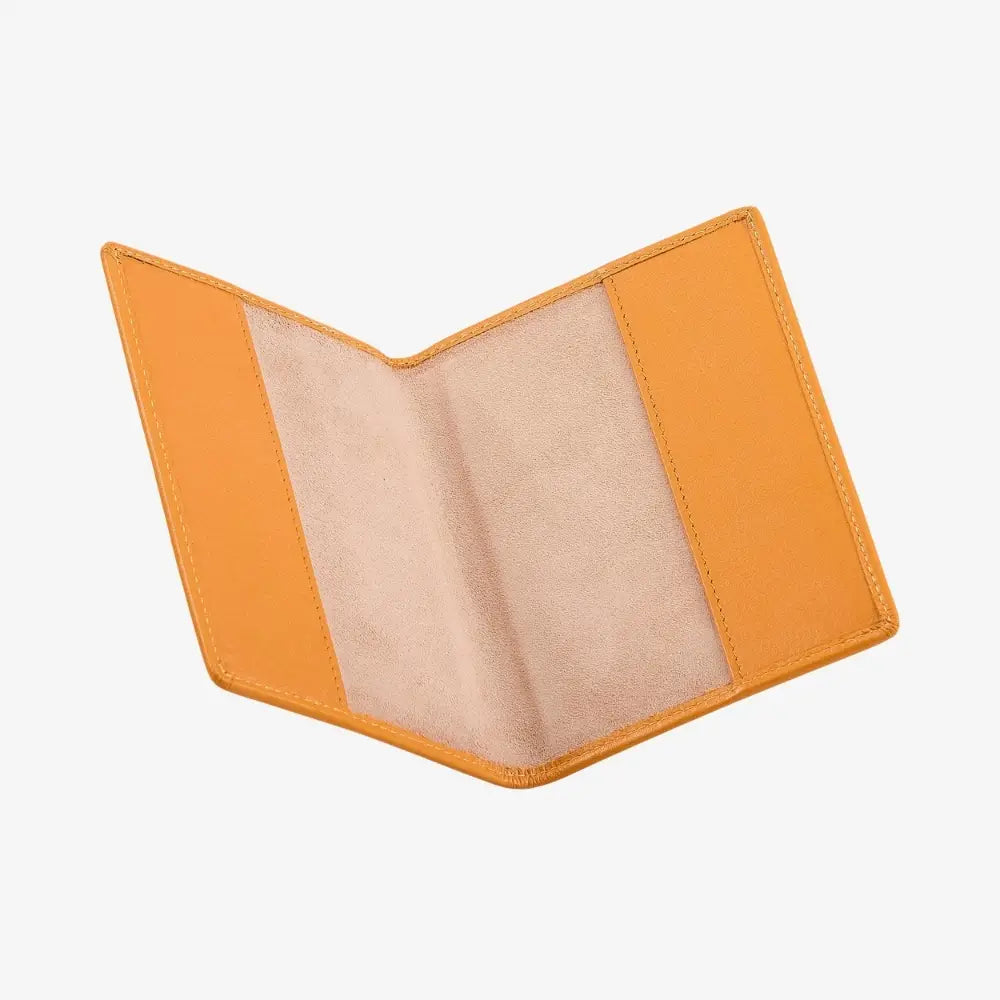 An open leather passport holder made of orange leather, showing a light beige suede-like interior lining, photographed on a clean white background.