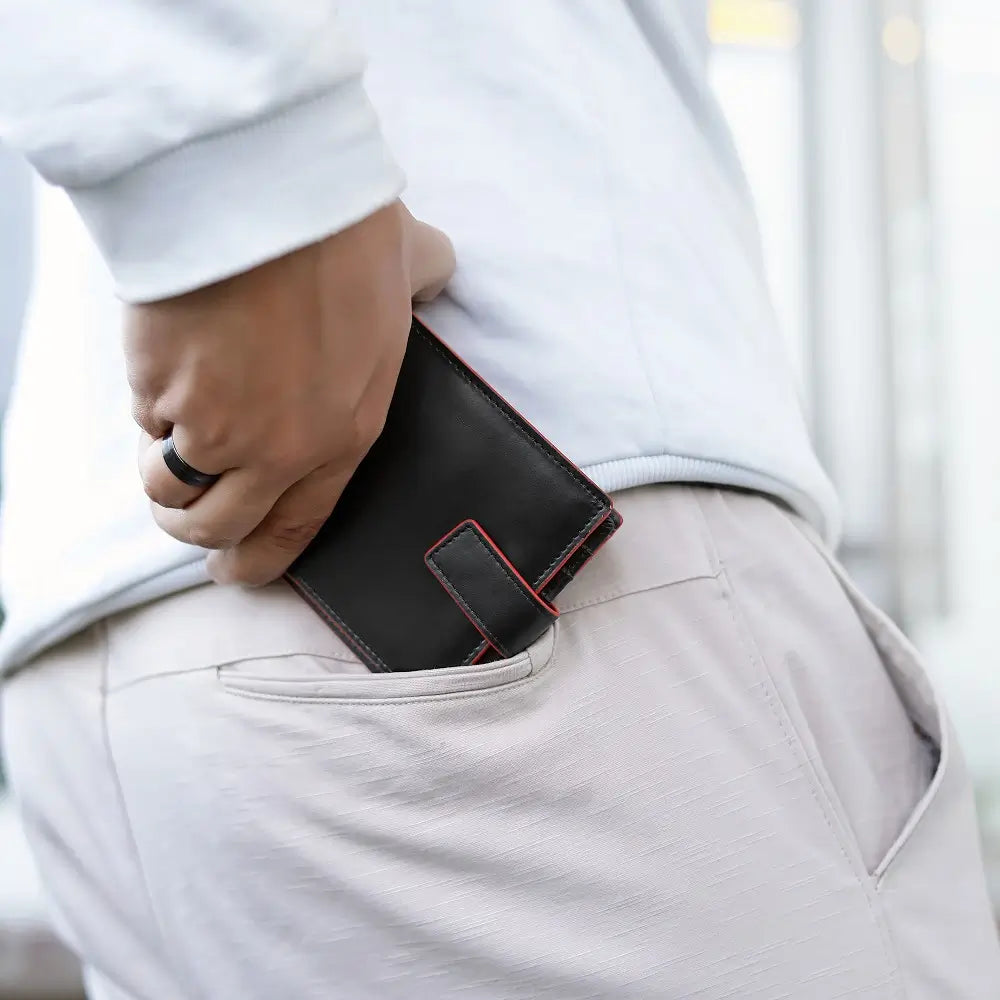Person putting a black wallet into their pocket