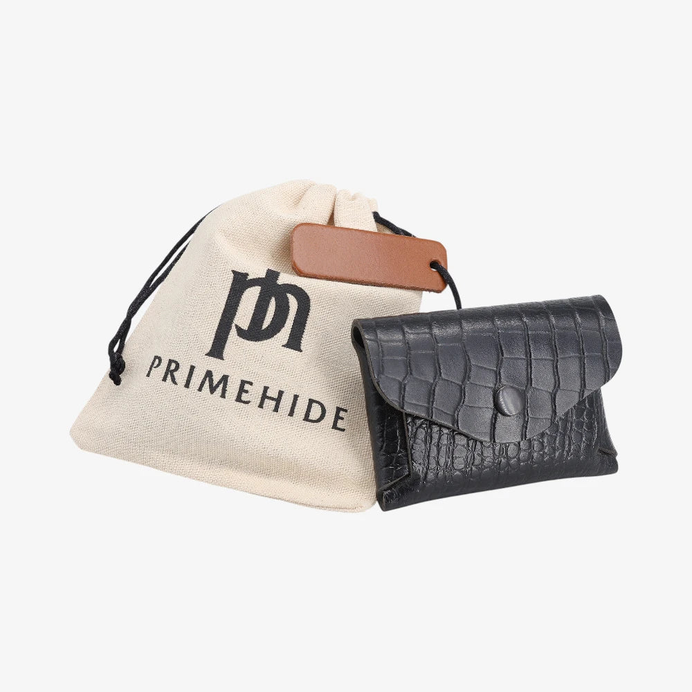 Black croc print leather coin purse with flap closed, displayed beside Primehide dust bag and tag