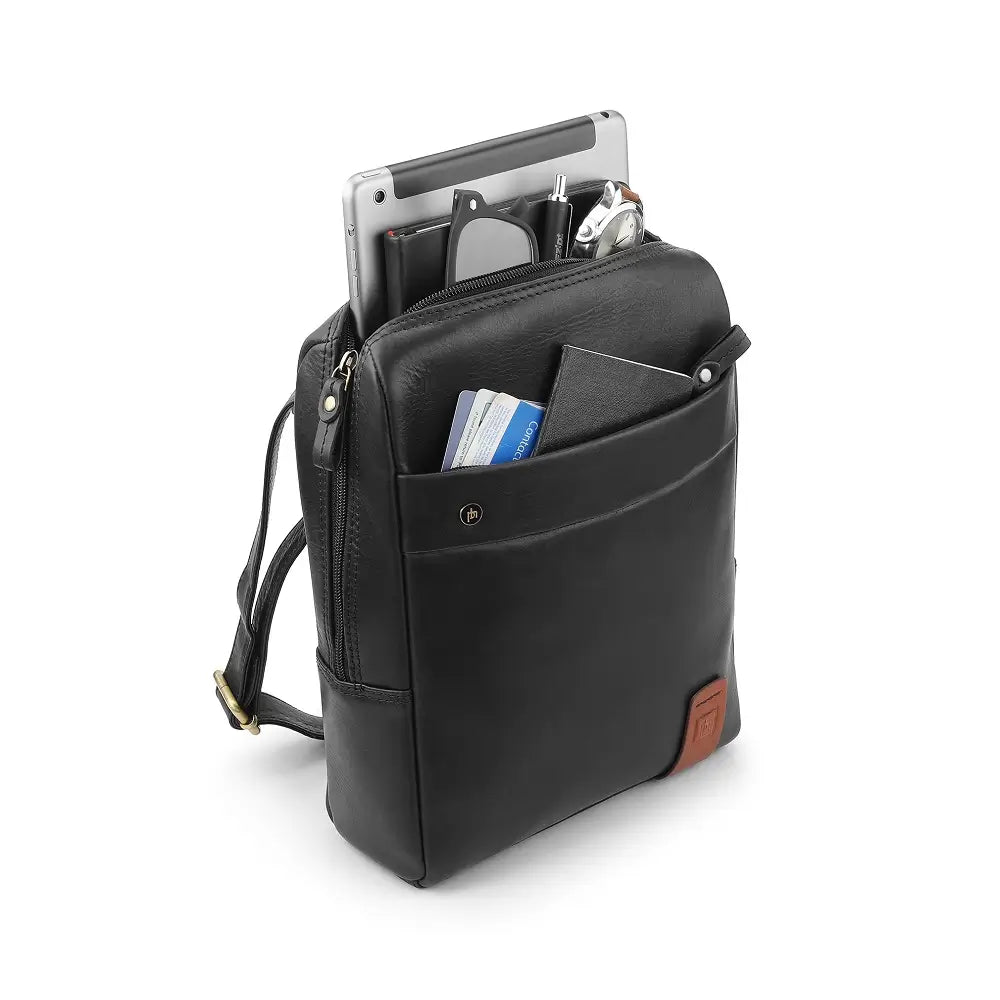 Black leather messenger bag with compartments containing a tablet, books, and a wallet on a white background
