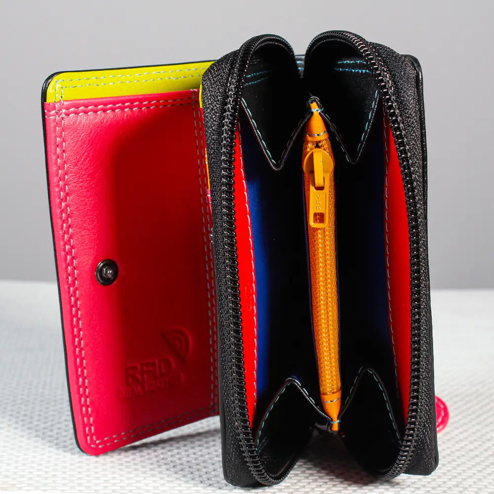 Black leather wallet with red interior and yellow pen on a gray background