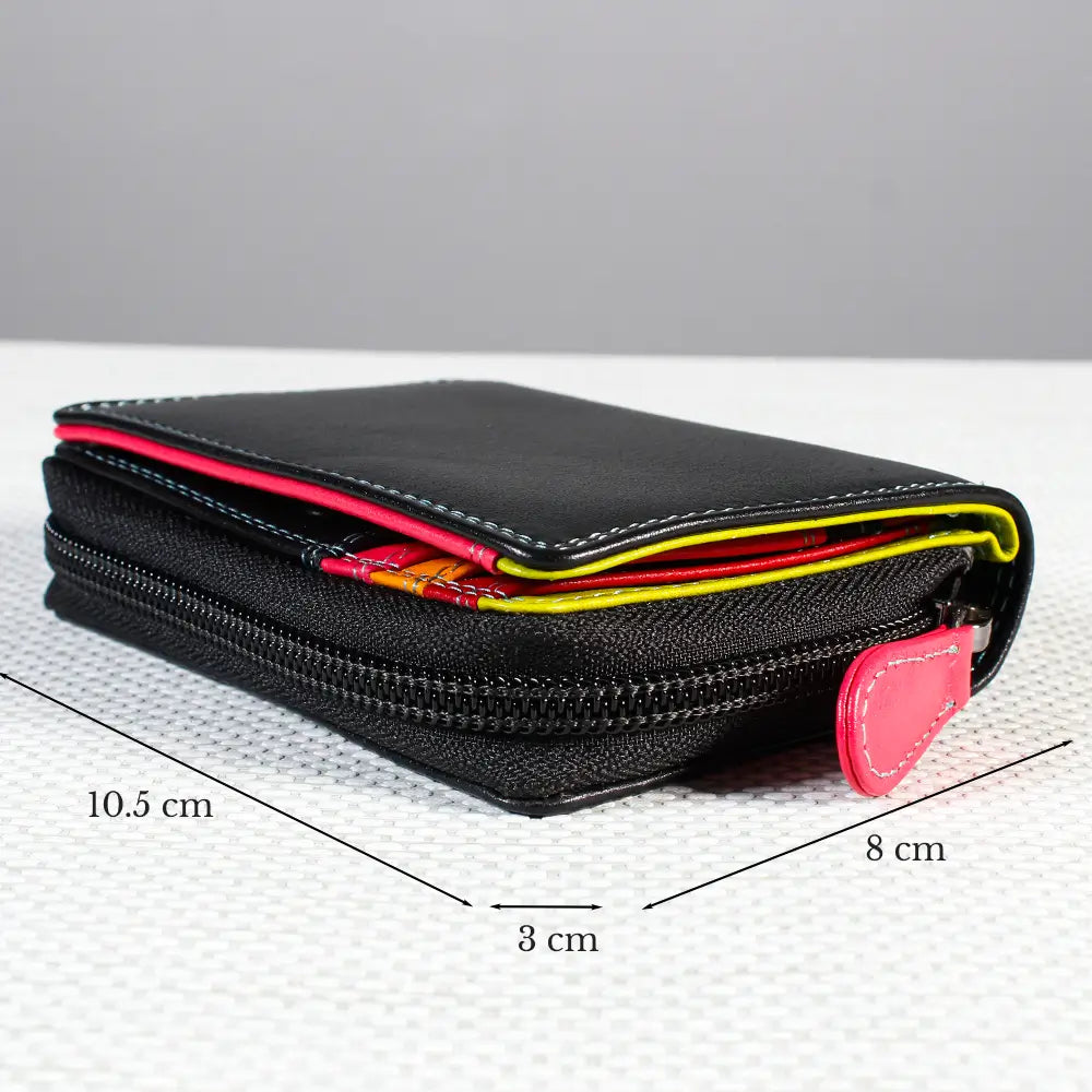 Black zippered wallet with bright pink and yellow accents, shown on a white textured surface.
