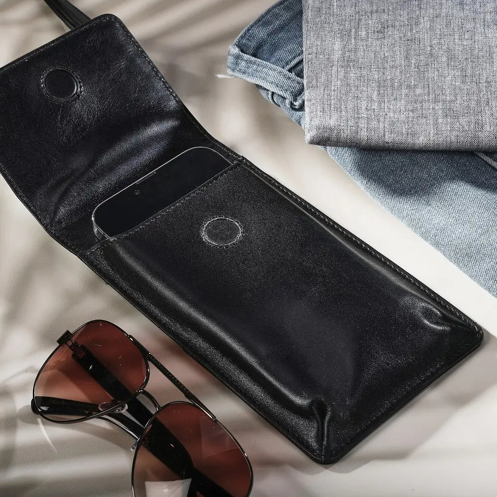 Black leather wallet with sunglasses on a light surface
