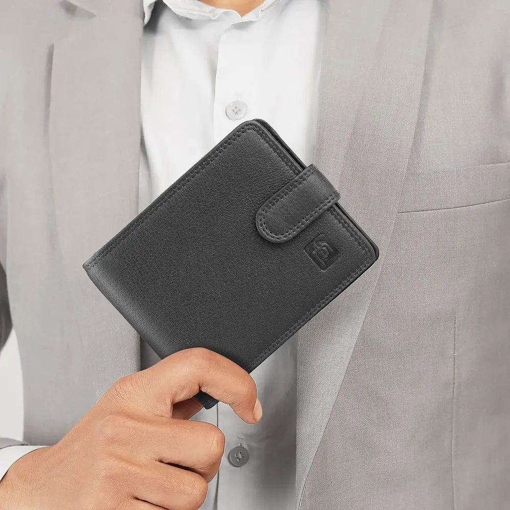 Person holding a black leather wallet with a visible brand logo.