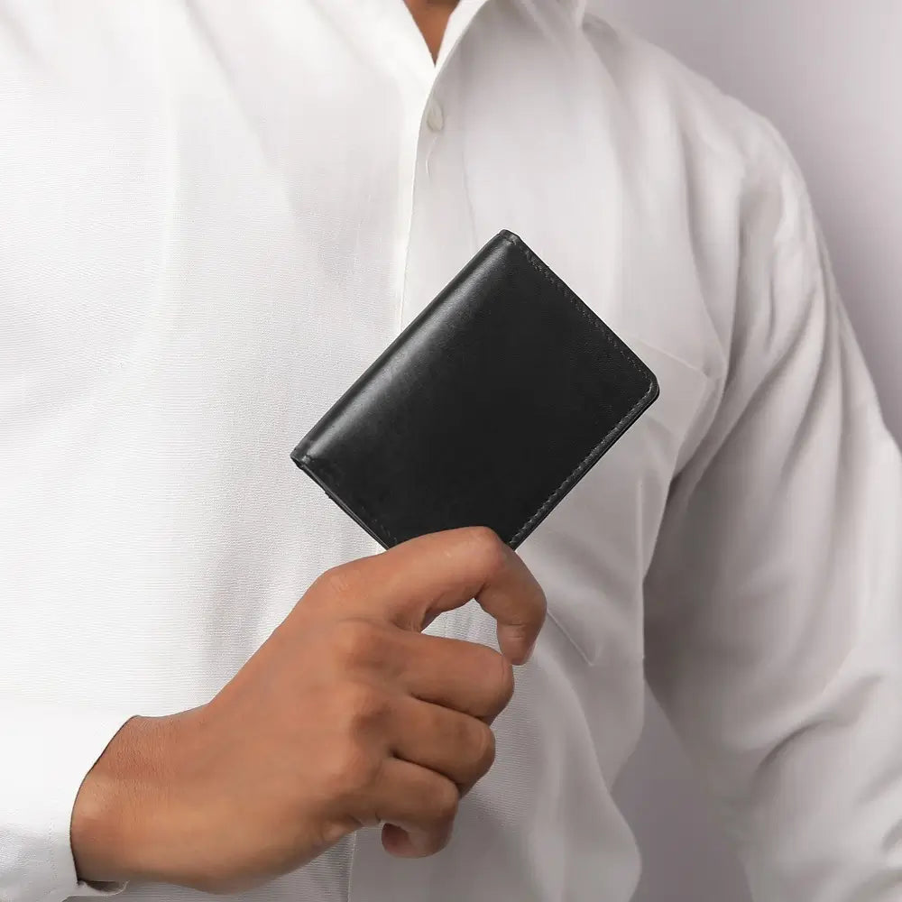 Black leather Mayfair 2511 cardholder held in hand, showing its compact and refined design.