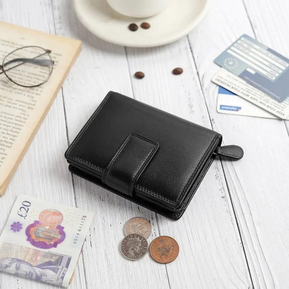 Soft navy leather trifold purse with secure tab fastening – flat lay view