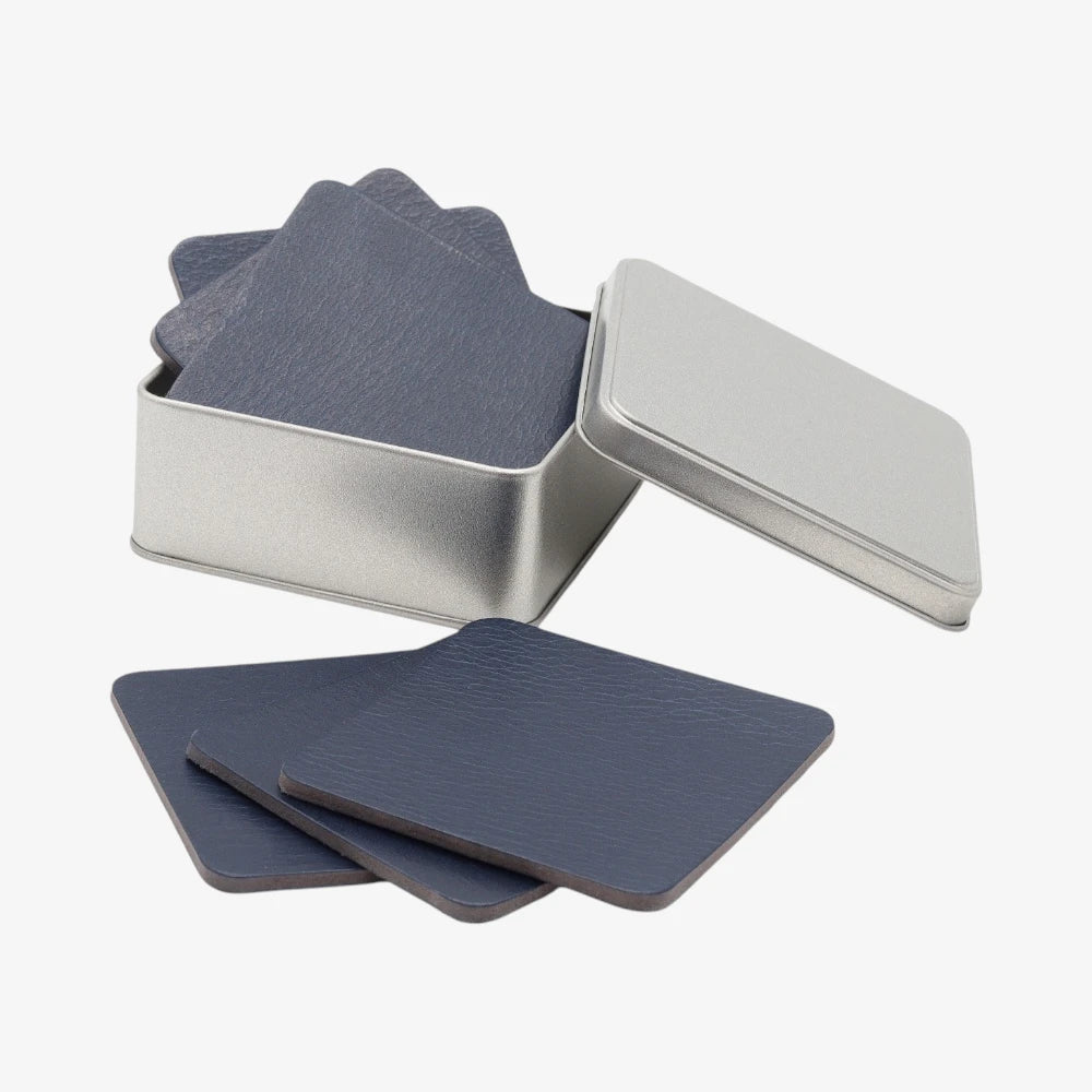 Set of blue coasters in a metal tin on a white background