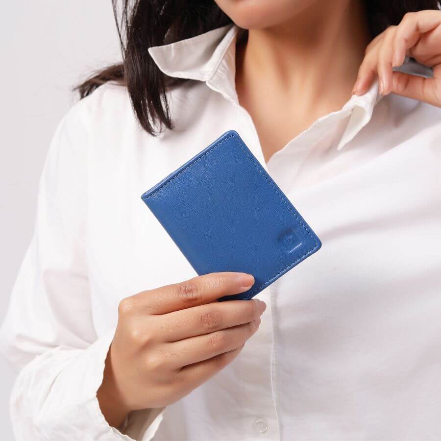 Person holding a blue wallet against a white background