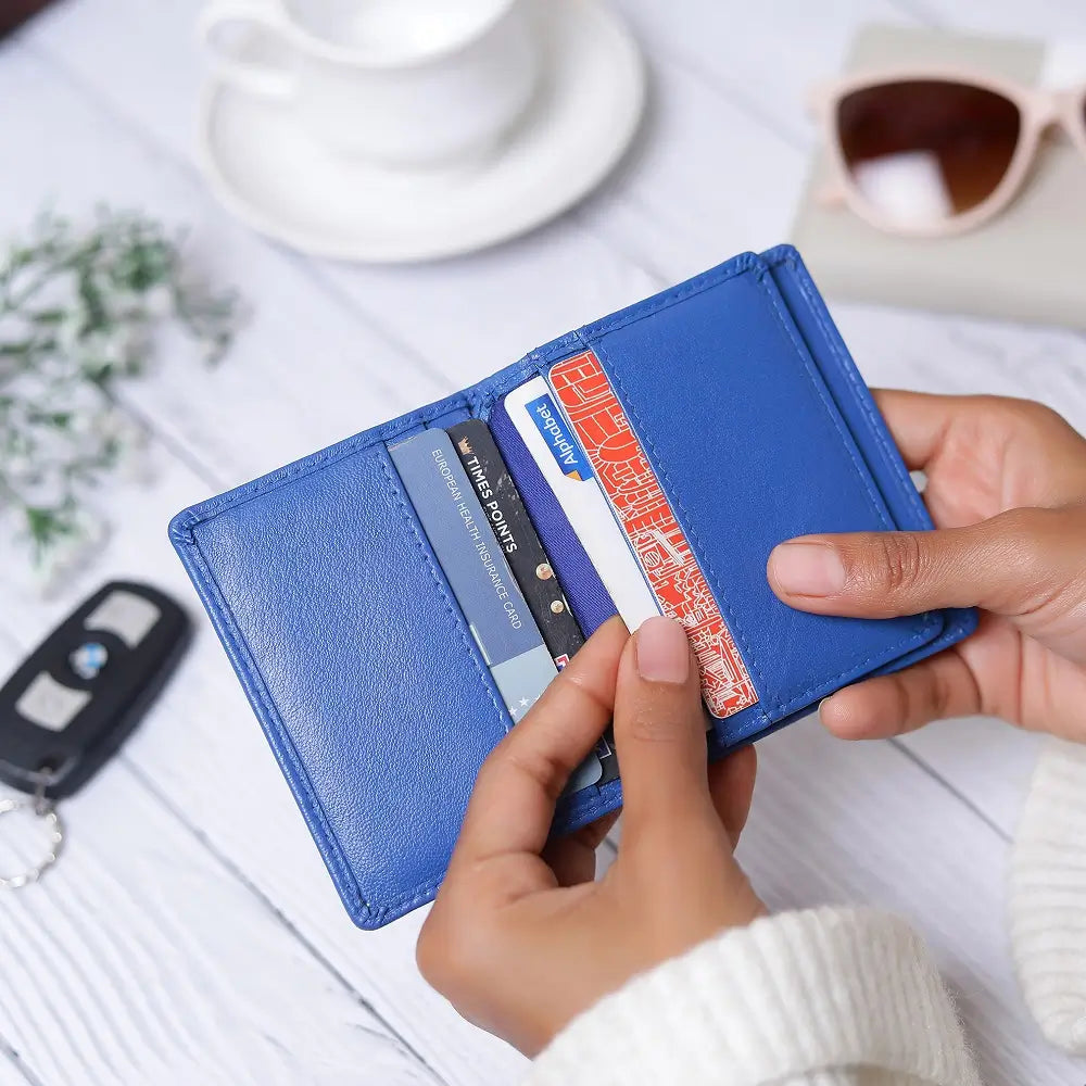 Person holding a blue wallet against a white background