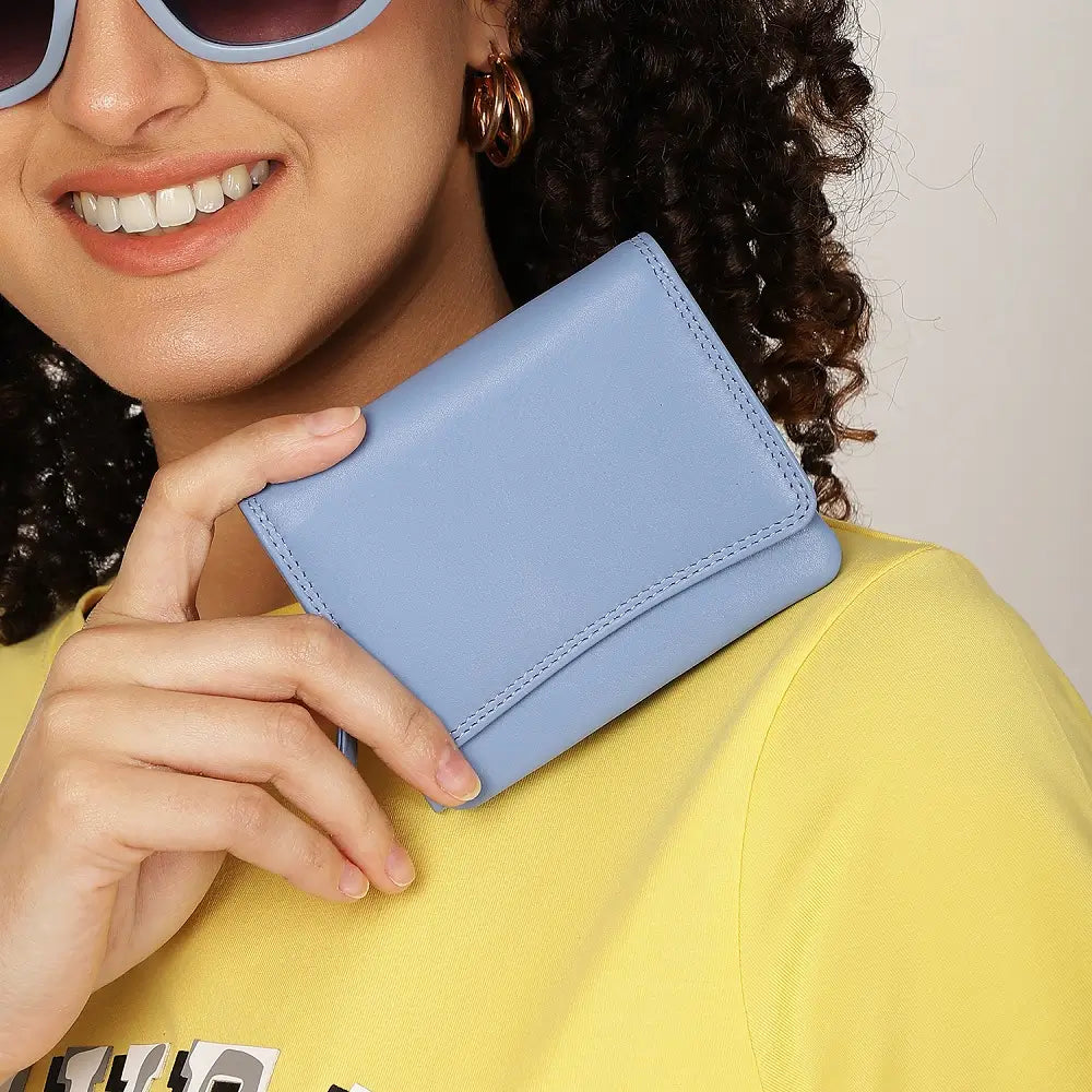 Person holding a blue wallet with a neutral background