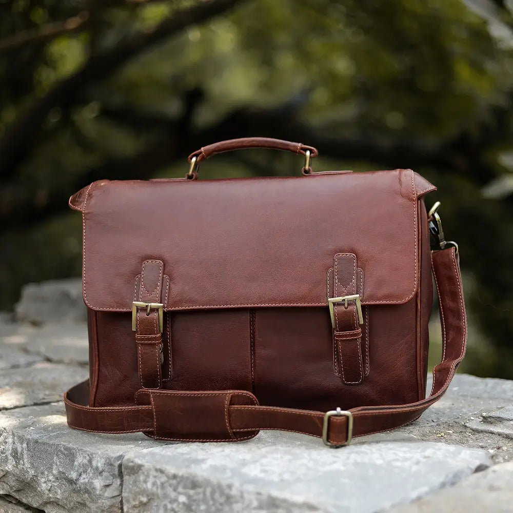 Brown leather satchel bag on a stone surface with a blurred natural background