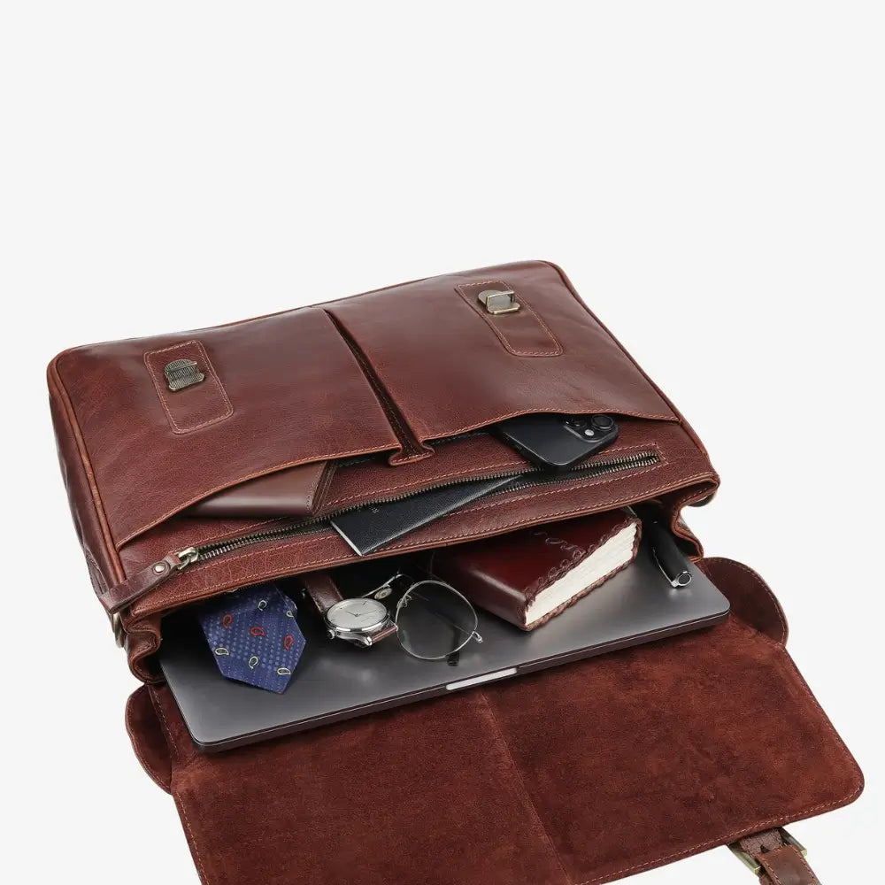 Brown leather laptop bag with compartments and items inside on a white background