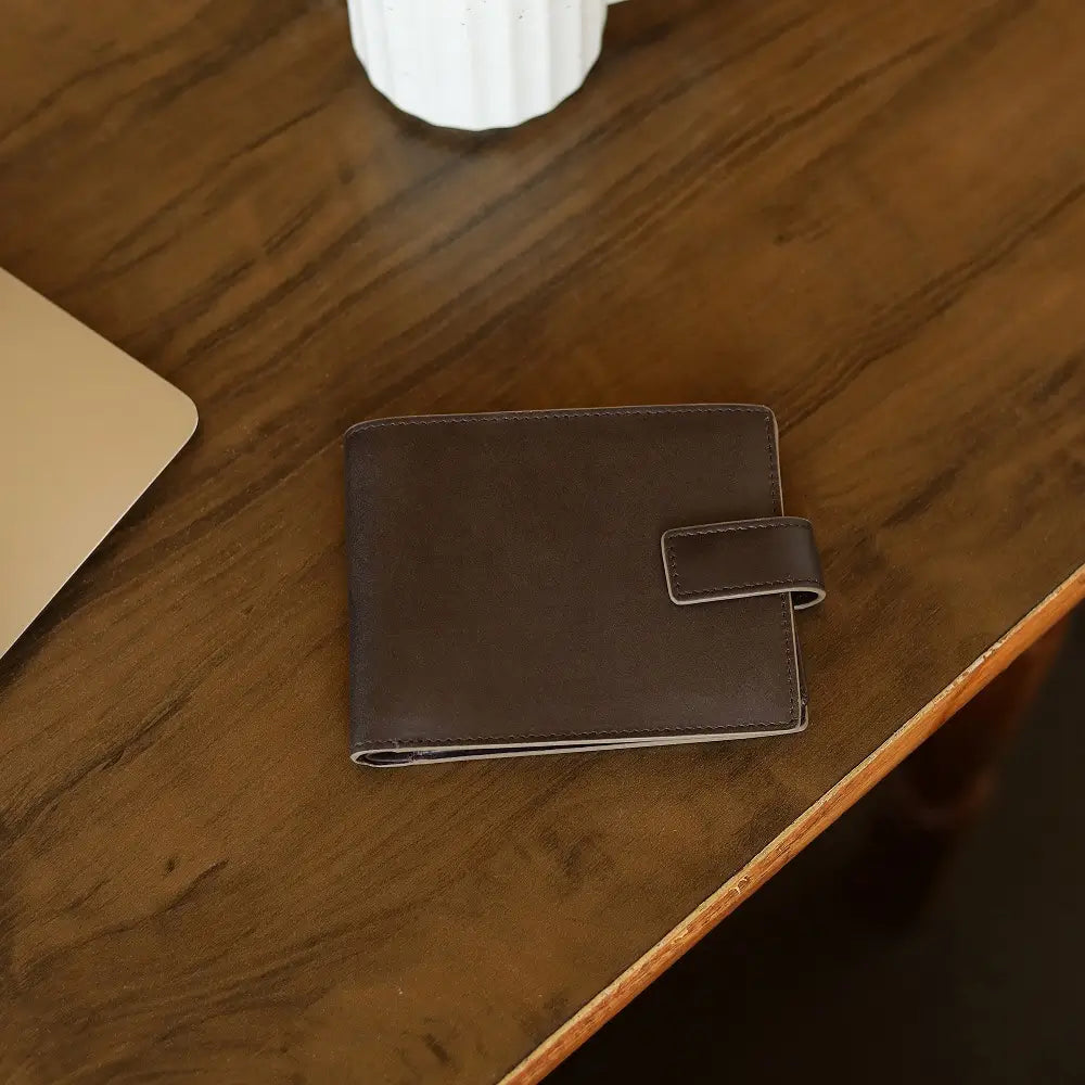 Brown leather wallet on a wooden surface