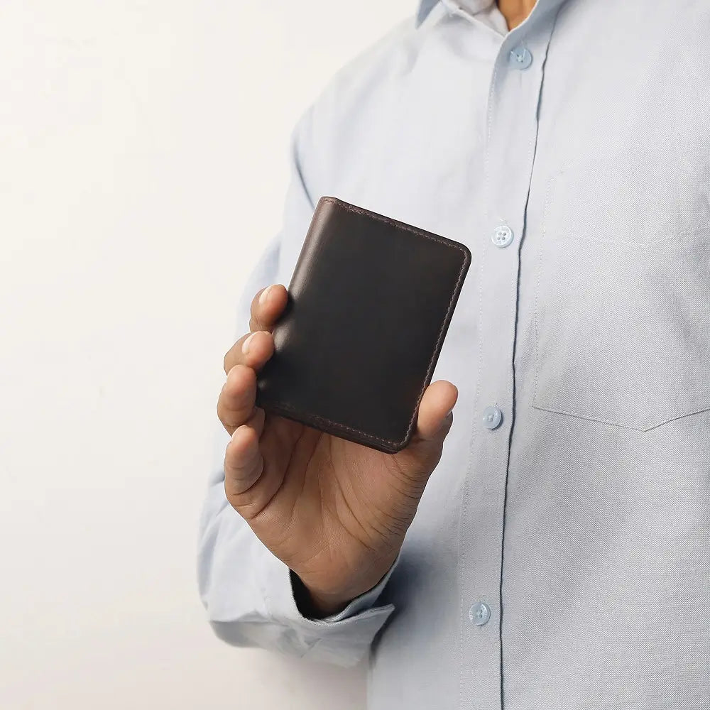 Brown leather Mayfair 2511 cardholder held in hand, showing its compact and premium craftsmanship.