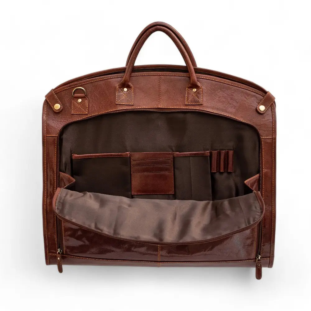 Cognac leather garment bag with interior compartments on a white background