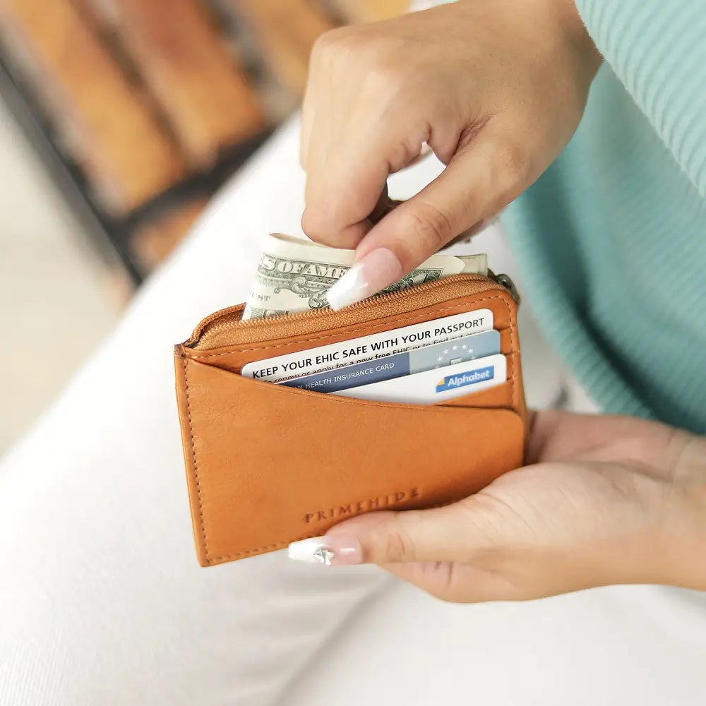 Person holding a Cognac wallet with money and cards on a blurred background