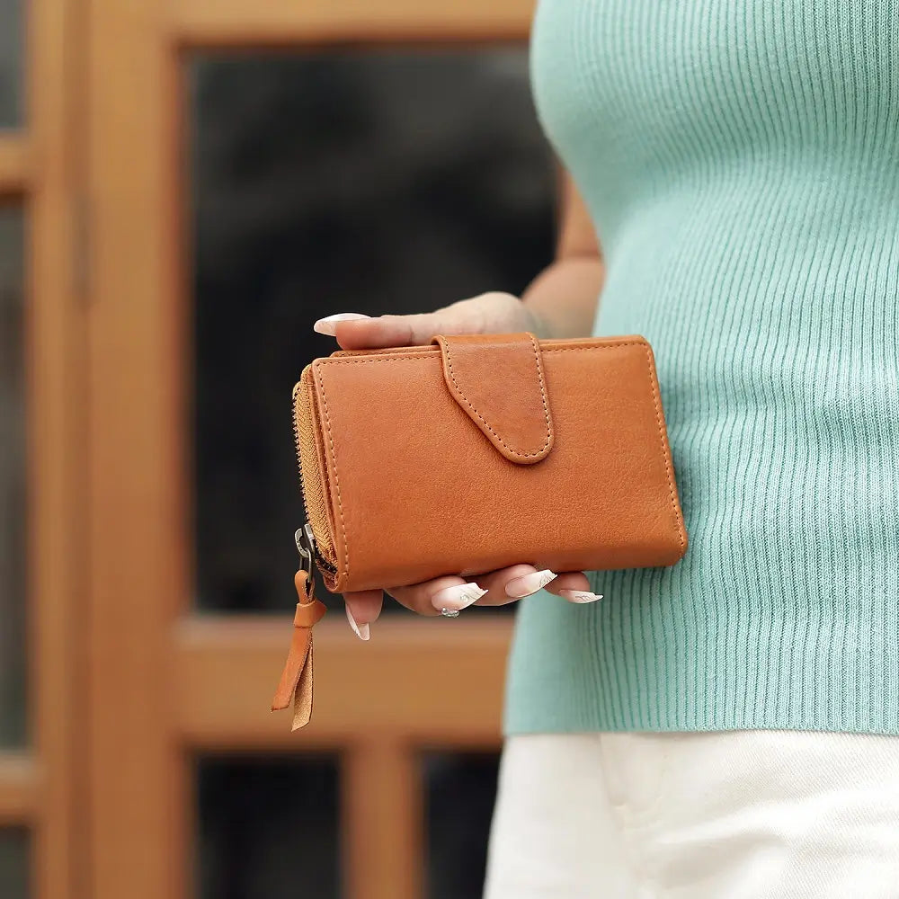 Cognac Renata bifold purse in washed Cancun leather held in hand