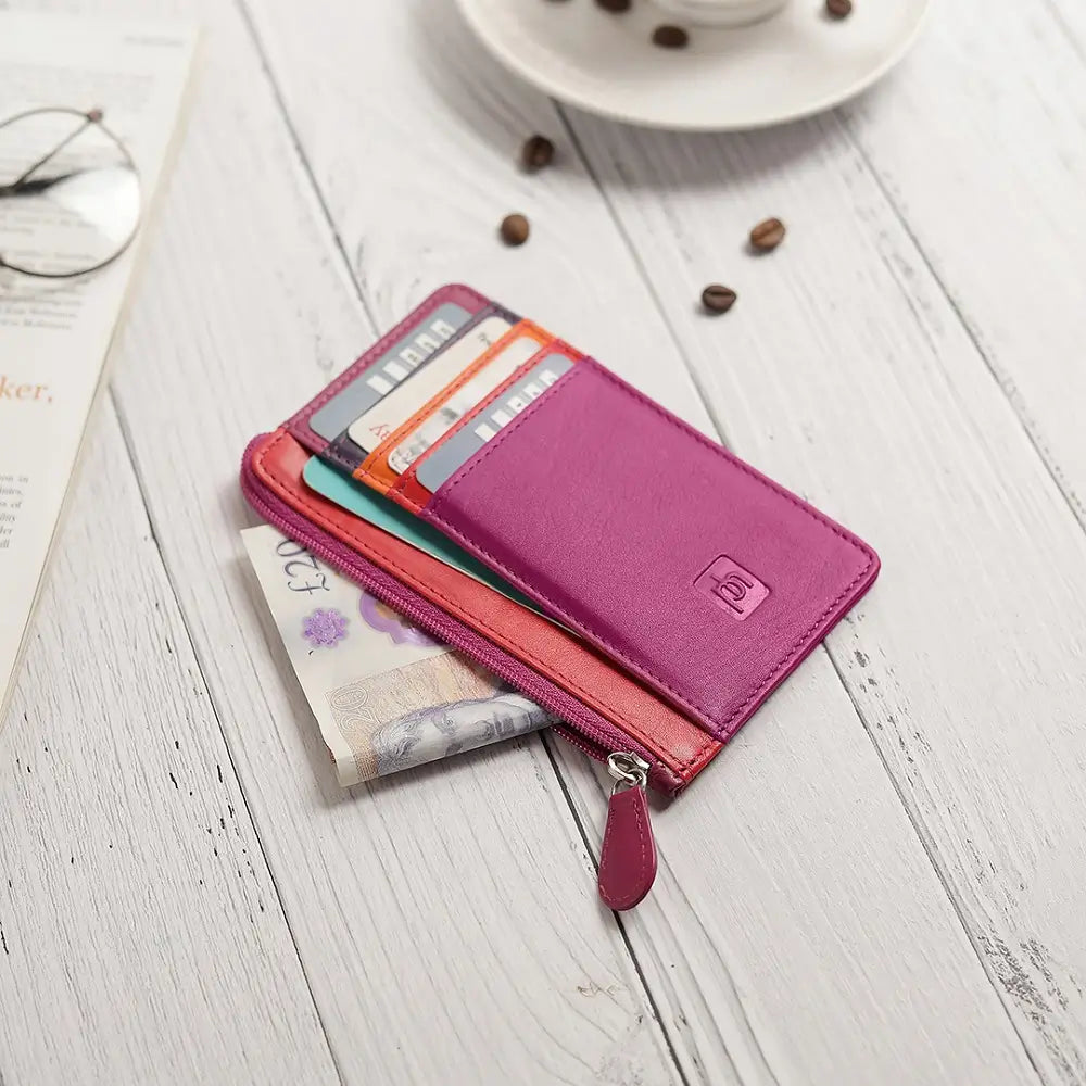 Fuchsia Card Holder Purse with cards and money on a wooden surface with coffee beans and glasses.