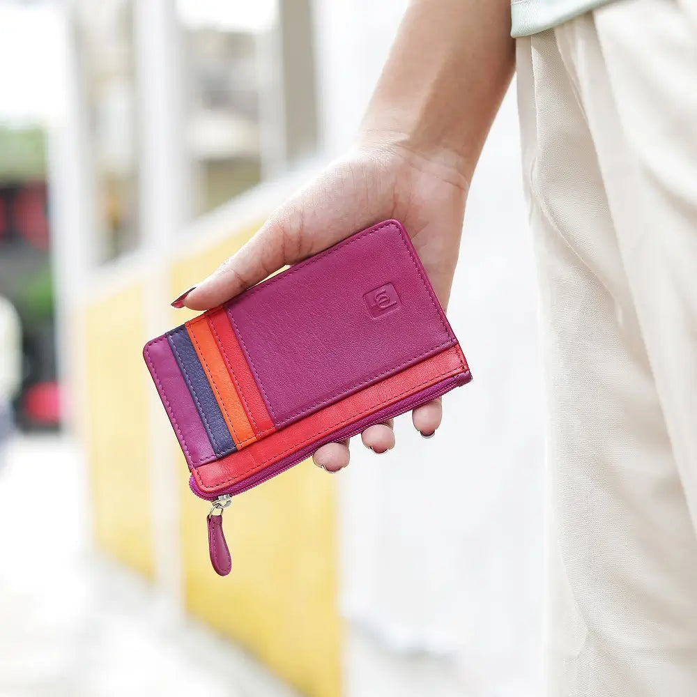 Hand holding a Fuchsia  Card Holder Purse with a blurred background