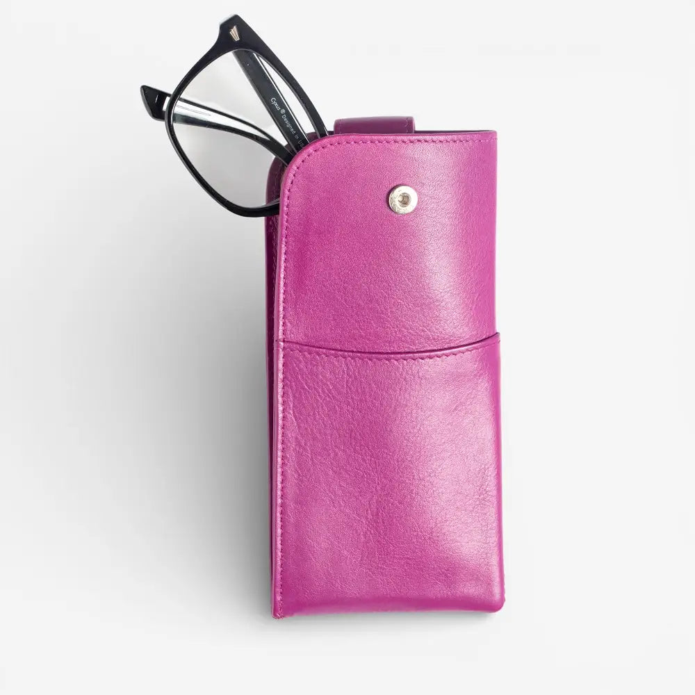 Fuchsia leather glasses case with a pair of glasses on a white background