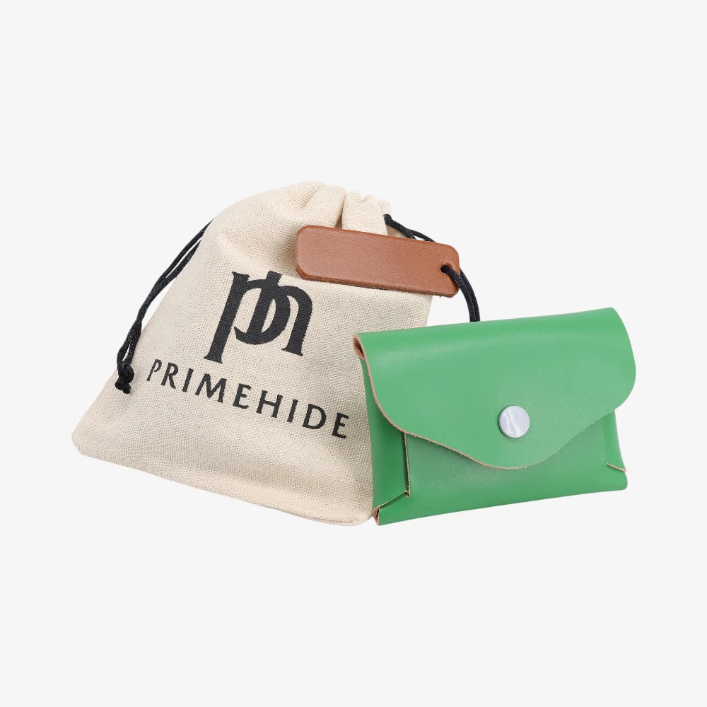 Garden green leather coin purse with flap closed displayed beside Primehide dust bag