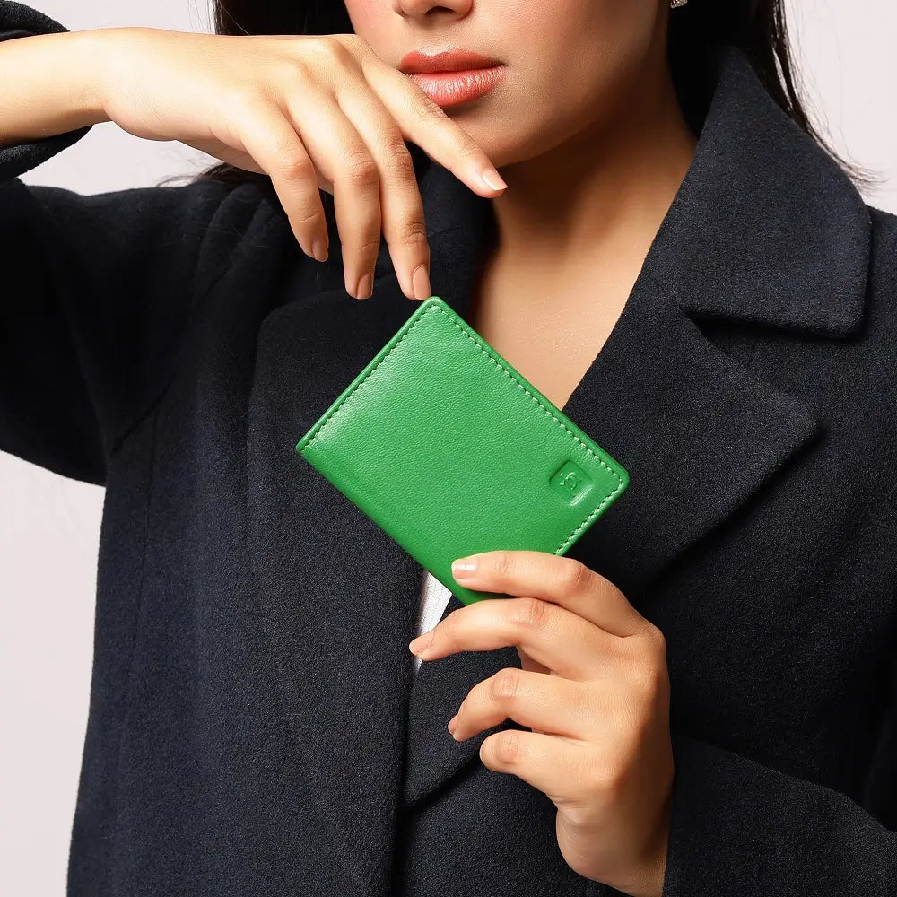 Person holding a green wallet against a neutral background