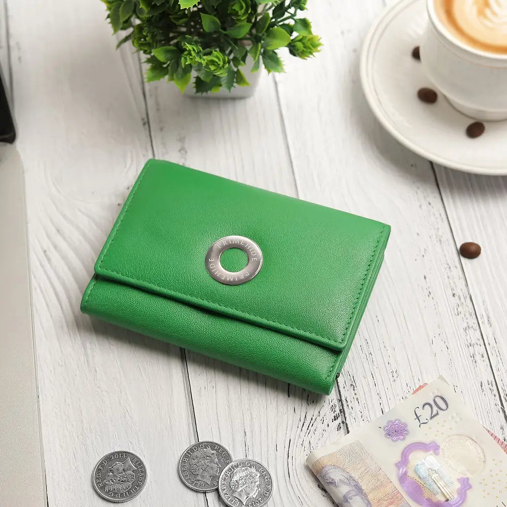 Green wallet on a wooden surface with coins and banknotes