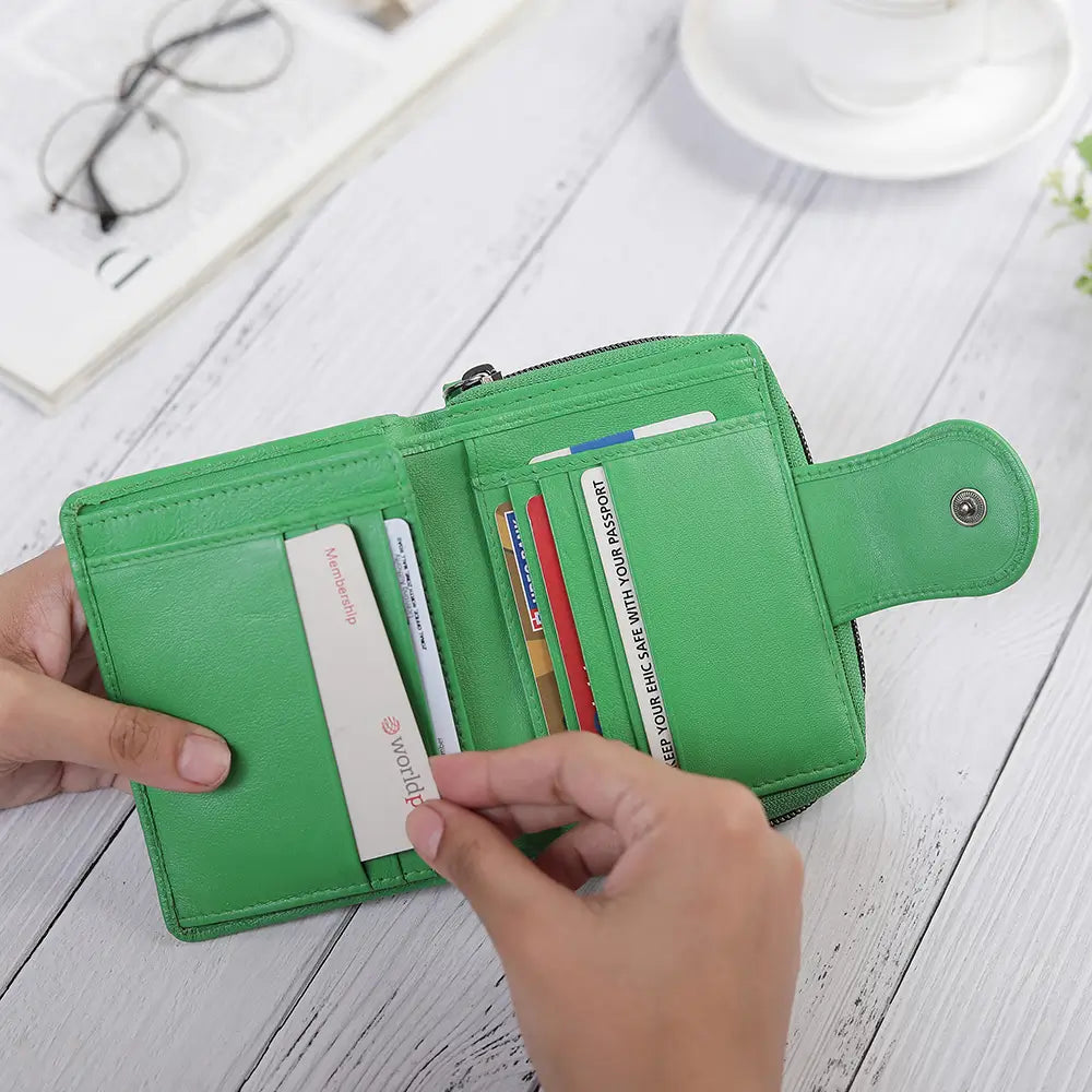 Green wallet with cards on a white wooden surface