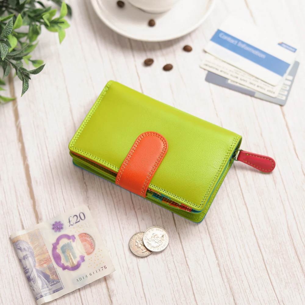 Green wallet with orange accent on a wooden surface with money and a plant.