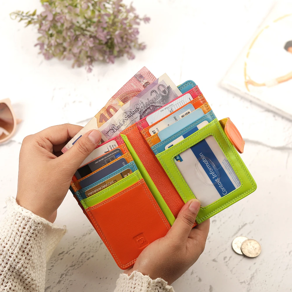 Green wallet with cards held by a person on a light background