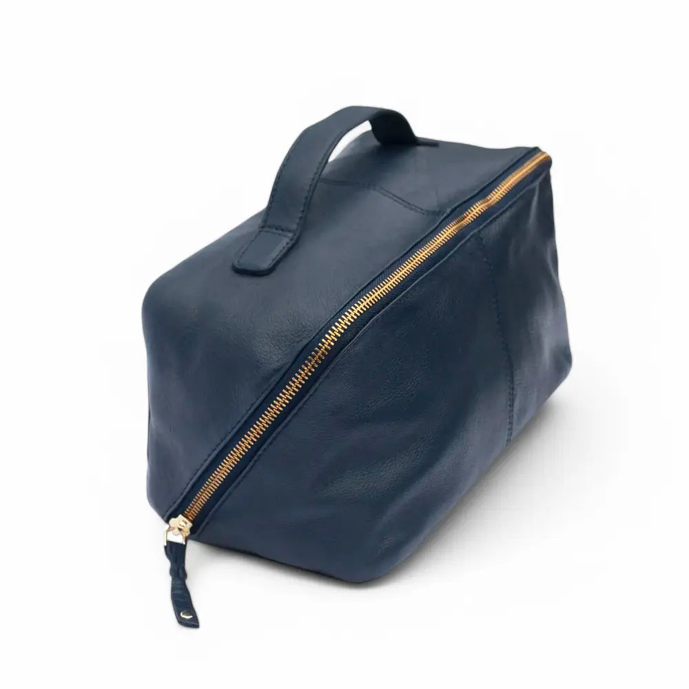 Large Leather Makeup Washbag in navy blue, showcasing its soft leather exterior, structured rectangular shape, and sturdy top handle.