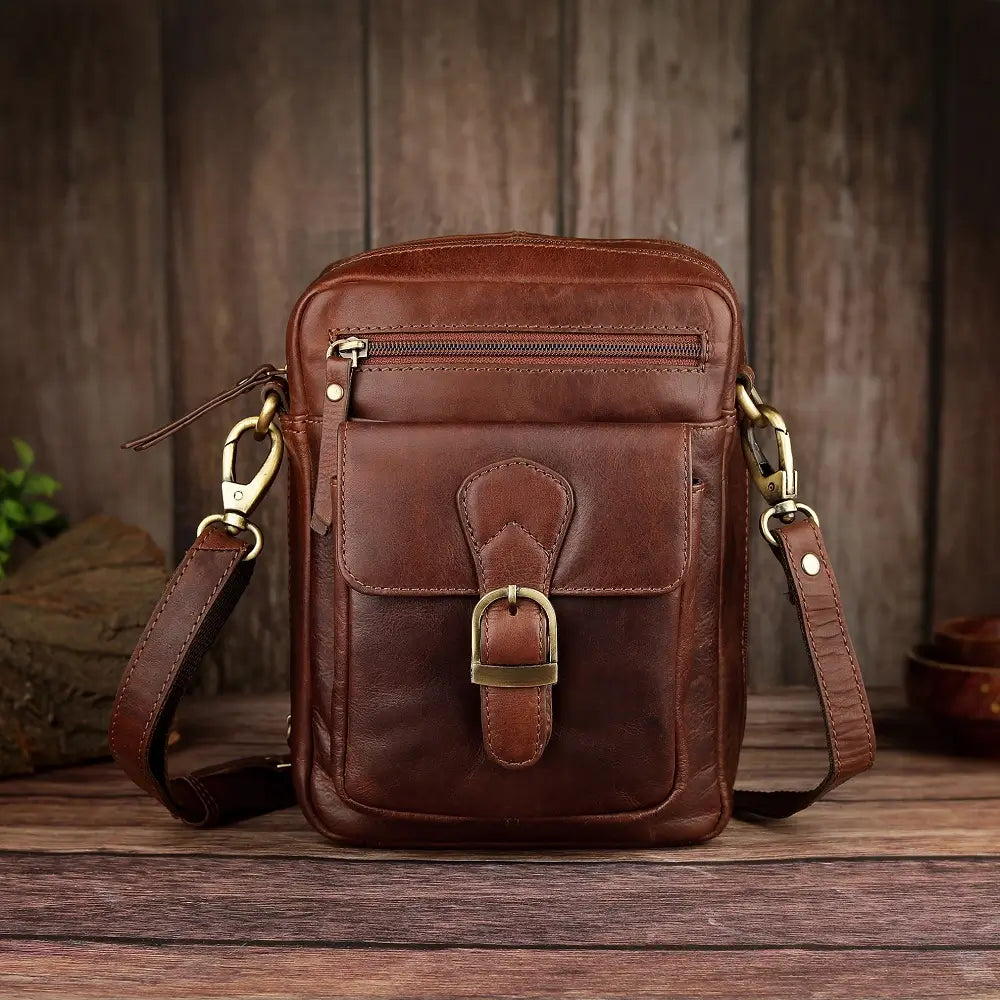 Slim side profile of brown leather crossbody messenger bag with adjustable shoulder strap and metal hardware