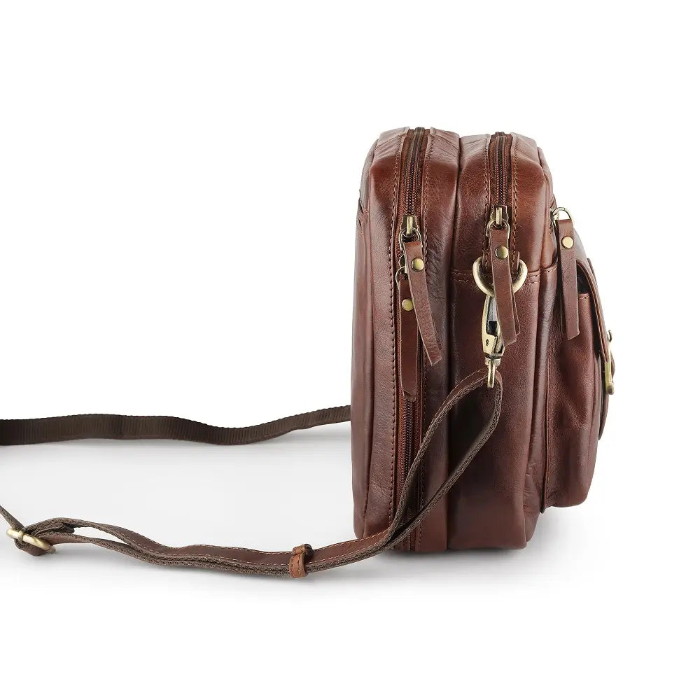 Angled side view of brown leather crossbody messenger bag showing dual compartments and sturdy stitching