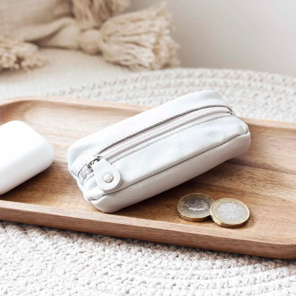 Life style view of Ligth Grey Small Leather Zipper Keyring Pouch on grey background